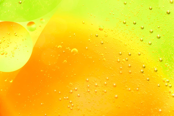 Water and oil bubble yellow orange background. Macro shot of beautiful water and oil bubble background , with small and big bubbles - Fotó, kép