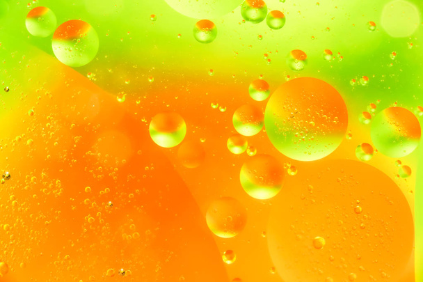 Wody i oleju bubble żółty pomarańczowy tło. Strzał makro piękne wody i oleju bubble tło, z dużych i małych pęcherzyków - Zdjęcie, obraz