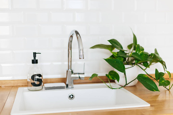 White sink soap dispenser wooden countertop and white ceramic brick tile background. White scandinavian kitchen details - Foto, immagini