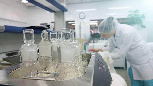 Une assistante de laboratoire vérifie les échantillons de produits laitiers dans le laboratoire
 - Photo, image