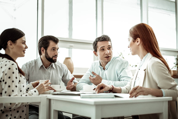 Pessoa masculina atenta falando com seu companheiro de grupo
 - Foto, Imagem