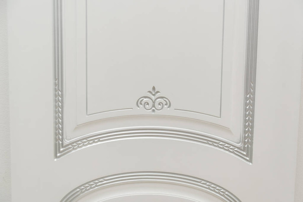 Door painted white. Wood carving. Metal door handle. Anti-burglar armored door. Metal interior doors. The design of the door. Interior. - Valokuva, kuva