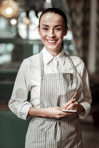 Pretty young waitress looking straight at camera - Foto, afbeelding