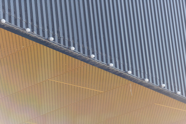 Corrugated aluminum. Finish exterior facades aluminum. Shopping center. Bulbs for night lighting. Metal panels for cladding. Ventilated facade. Yellow aluminum panel. - Photo, Image