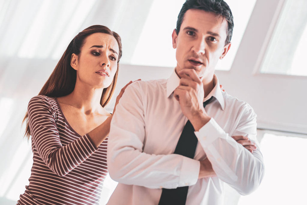 Young woman feeling worried while looking at her unhappy husband - Photo, Image
