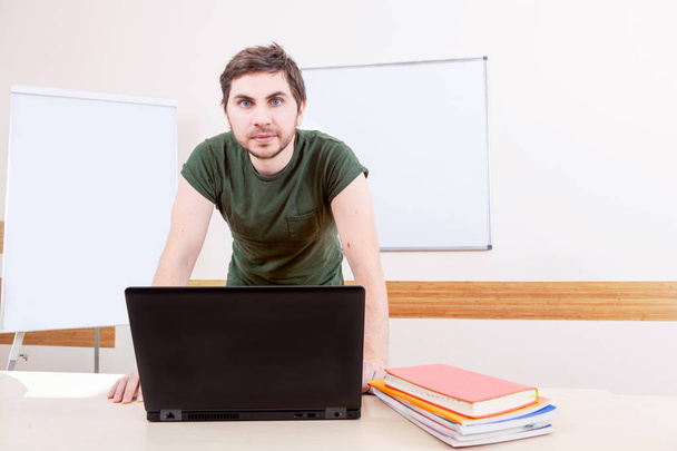レッスン教室で男性教師の非公式の肖像画。創造的な若者を教えるコンピューターのオンライン. - 写真・画像