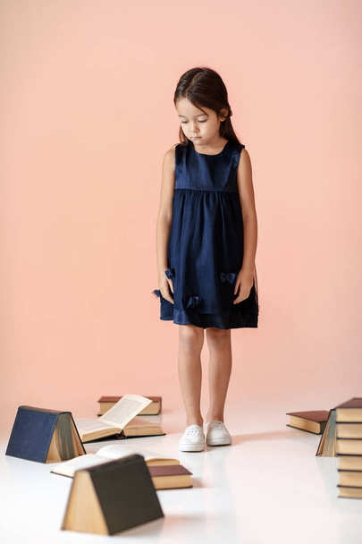 cute little girl is reading a book. - Фото, зображення