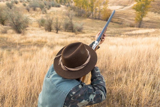 Hunter s kloboukem a pistolí při hledání kořisti ve stepi, se zaměřuje na kořist - Fotografie, Obrázek