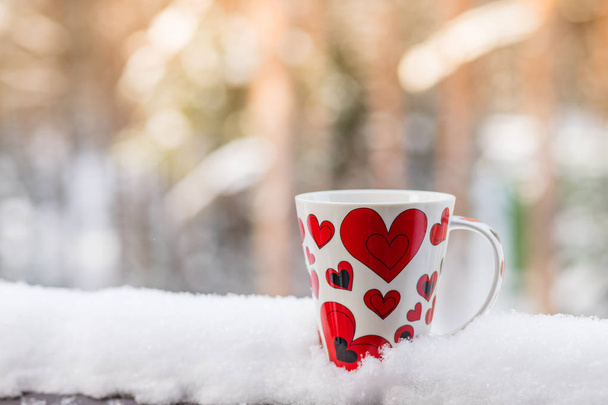 Valentines Day with red cup coffee on snow white background, copy space Valentine Concept.Warm and romantic atmosphere in a cold winter Valentines Day. Hot drinks outdoor. - Photo, Image