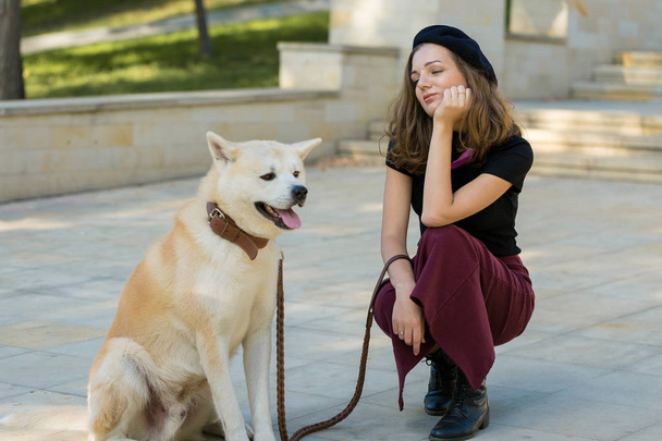 Fashionable french woman with a big white dog in the park - Photo, Image