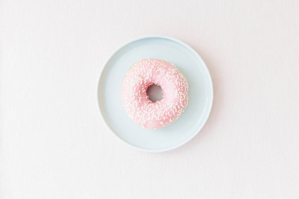Pink donats on blue plate pink backgrpund pastel colors. Sweet breakfast - Foto, imagen