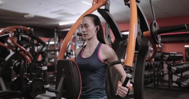 Femme forte travaillant sur la machine de poids en utilisant le traqueur d'activité
 - Séquence, vidéo