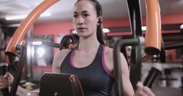 Mujer fuerte haciendo ejercicio en la máquina de peso usando el rastreador de actividad
 - Imágenes, Vídeo
