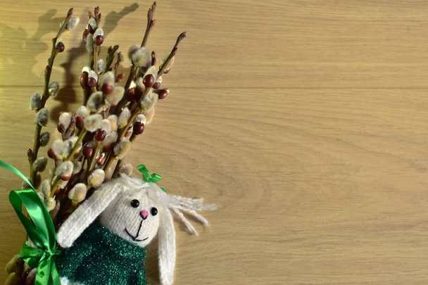 Hermoso ramo de amentos de sauce y pequeño juguete - conejito, sobre fondo de madera para pascua y primavera saludos y copyspace
 - Foto, imagen