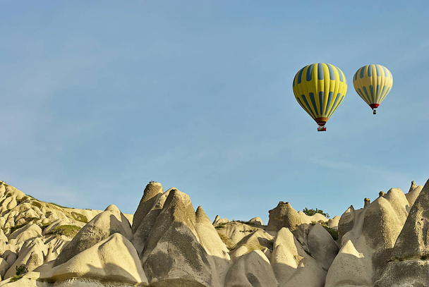 Πολύχρωμα αερόστατα που πετούν πάνω από την κοιλάδα στην Καππαδοκία. Αερόστατα θερμού αέρα είναι παραδοσιακή τουριστική ατραξιόν της Καππαδοκίας. - Φωτογραφία, εικόνα