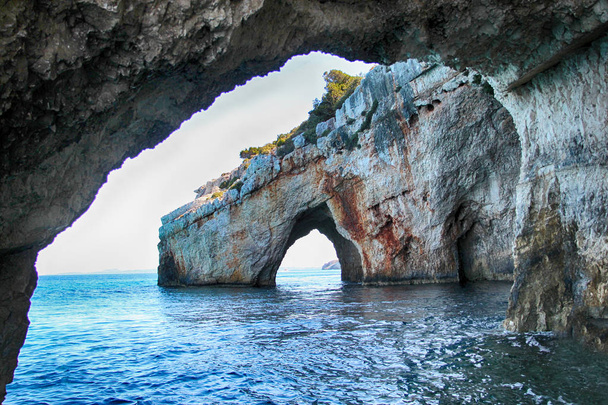 blaue Höhlen am Meer in Zakynthos in Griechenland. klares Wasser des Medditerischen Meeres an einem sonnigen Sommertag. - Foto, Bild