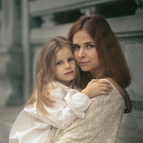 Beautiful portrait of a mother holding daughter outdoor - Fotoğraf, Görsel