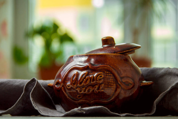 Stew in a clay pot on a wooden board. - Фото, зображення