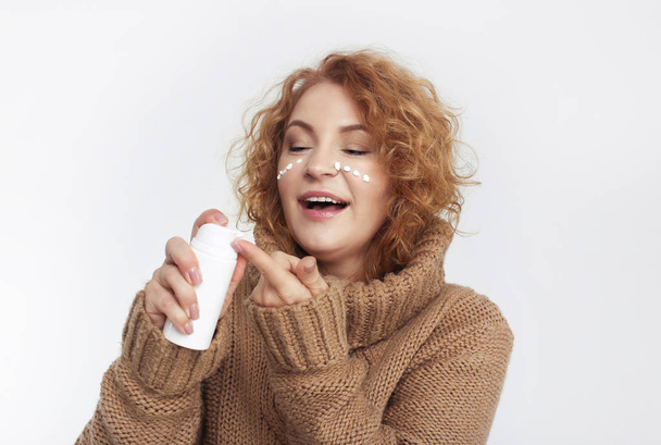 concepto antienvejecimiento: mujer de cuarenta años con crema para la piel
 - Foto, imagen