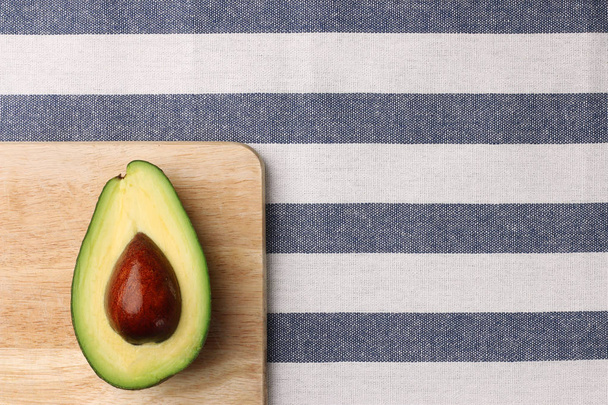 half avocado on wooden and textile background. top view - Foto, immagini
