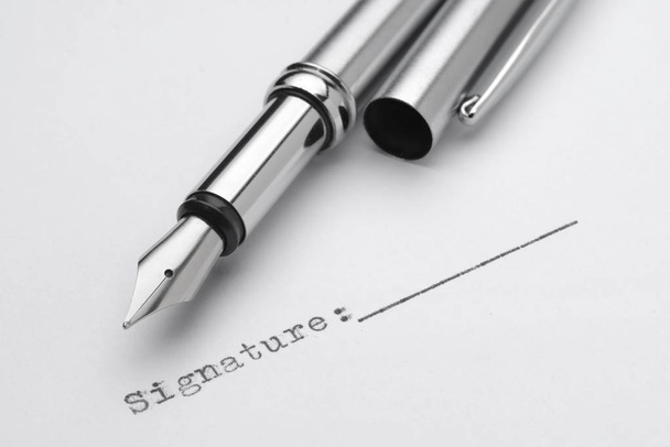 Πένα από ανοξείδωτο χάλυβα με πεδίο υπογραφής που εκτυπώνονται από γραφομηχανή. Συμφωνία ή σύμβαση σύνδεσης - Φωτογραφία, εικόνα