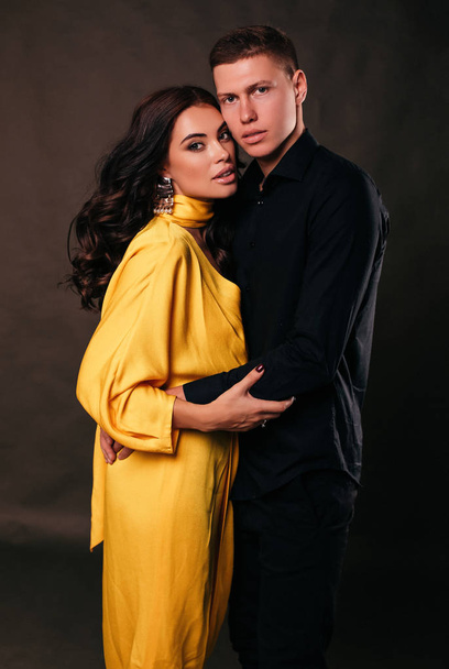 fashion  photo of beautiful lovely couple, Beautiful woman with dark hair posing with handsome man in elegant clothes - Фото, изображение
