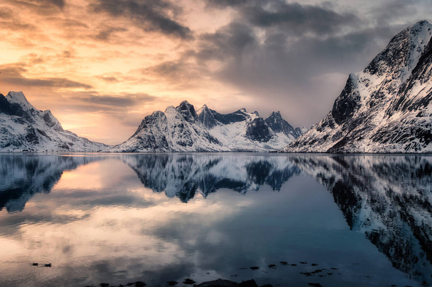 Reflexão montanha de neve no litoral ártico ao pôr-do-sol. Lofoten Islands, Noruega
 - Foto, Imagem