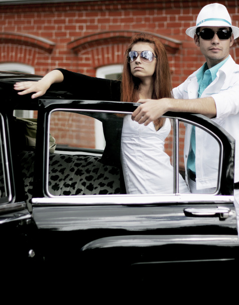 A young couple with a retro car - Фото, зображення