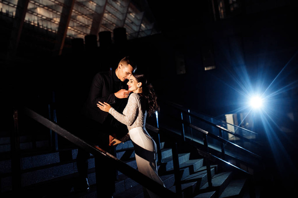 Beautiful young couple  posing on staircase at night - Foto, Imagem