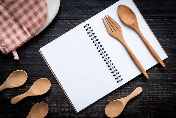 blank notebook for text note on wooden surface and wooden spoon and fork with copy sapce - Fotografie, Obrázek