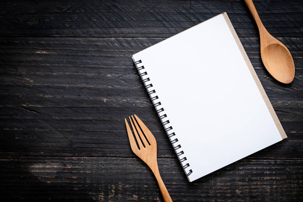 blank notebook for text note on wooden surface and wooden spoon and fork with copy sapce - Fotoğraf, Görsel