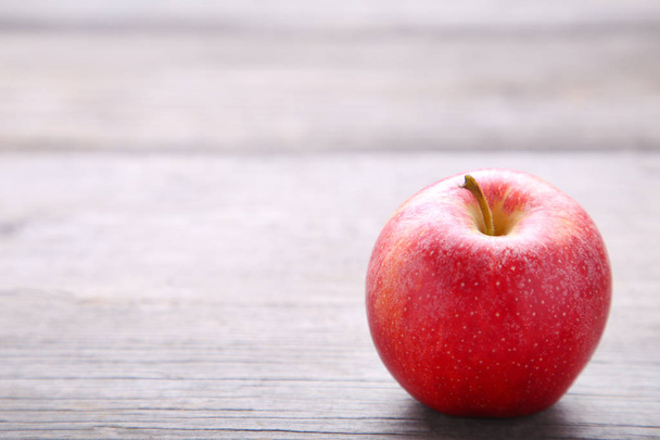 Φρέσκο κόκκινο μήλο σε γκρίζο φόντο ξύλινη - Φωτογραφία, εικόνα