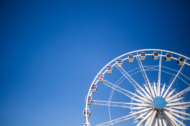 Close up images of a big sightseeing wheel against a blue sky - 写真・画像