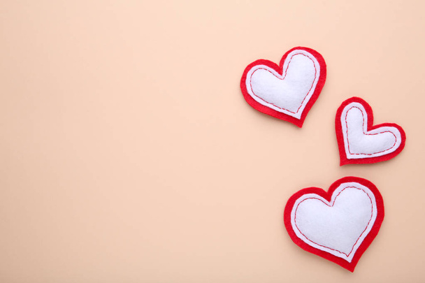 Вітальна листівка на день святого Валентина. Рукотворні серця на бежевому фоні. Вид зверху з пробілом для копіювання
 - Фото, зображення