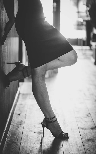 Close up image of sexy woman's legs standing in a hall way wearing high heels - Foto, Imagem