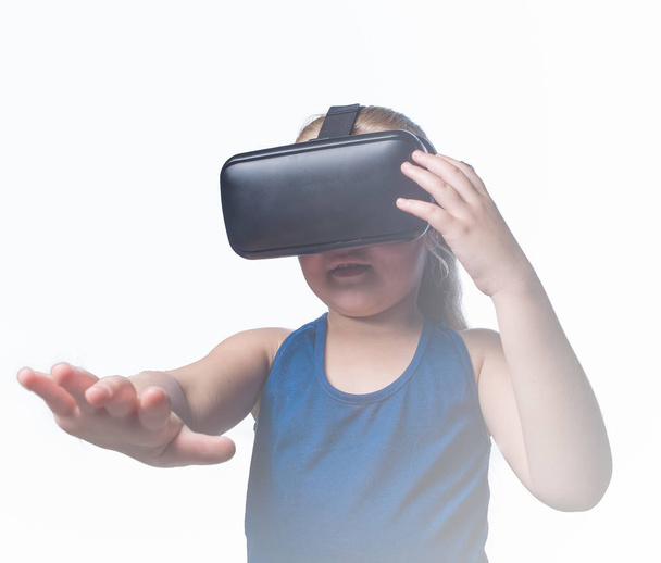 Close up image of a young toddler girl using a VR / Virtual Reality headset to look at amazing technological things - Foto, afbeelding
