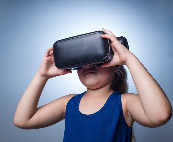 Close up image of a young toddler girl using a VR / Virtual Reality headset to look at amazing technological things - Foto, immagini