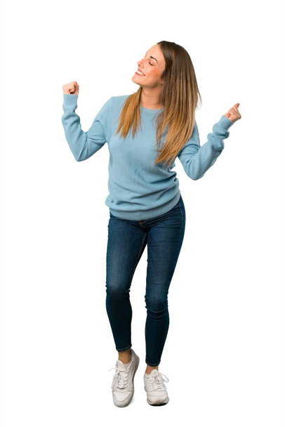 Full body of Blonde woman with blue shirt celebrating a victory on white background - Photo, Image