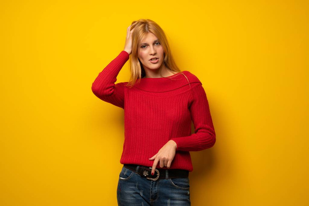 Блондинка над жовтою стіною з виразом розчарування і не розуміння
 - Фото, зображення