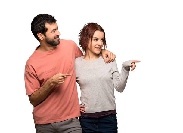 Couple in valentine day pointing finger to the side on isolated white background - Photo, image
