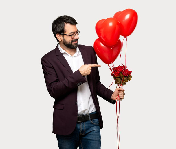 Man in valentine day pointing finger to the side in lateral position over isolated grey background - Фото, зображення