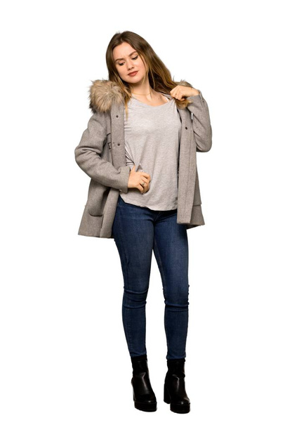 A full-length shot of a Teenager girl with coat with a lot of heat on isolated white background - Foto, immagini