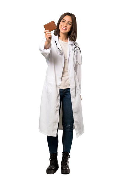 Een full-length shot van een jonge doctor vrouw houdt van een portefeuille over geïsoleerde witte achtergrond - Foto, afbeelding