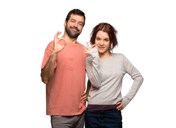 Couple in valentine day showing an ok sign with fingers on isolated white background - Фото, изображение