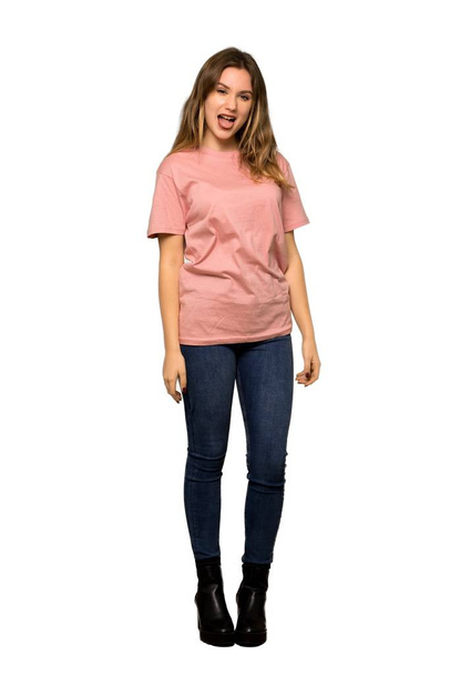 口を大きく開いて横方向の分離の白い背景の上に、ピンクのセーターとティーンエイ ジャーの女の子のフルレングス ショット - 写真・画像