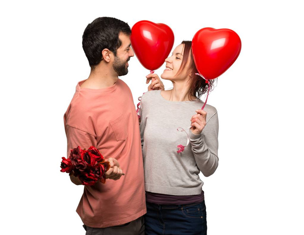 Couple in valentine day holding a heart symbol and balloons on isolated white background - Foto, imagen