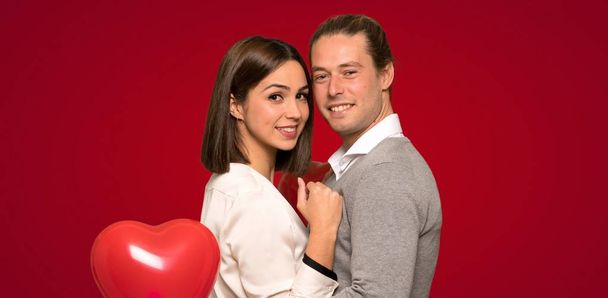Happy couple in valentine day over red background - Photo, Image