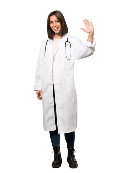 Un plan complet d'une jeune femme médecin saluant avec la main avec une expression heureuse sur fond blanc isolé
 - Photo, image