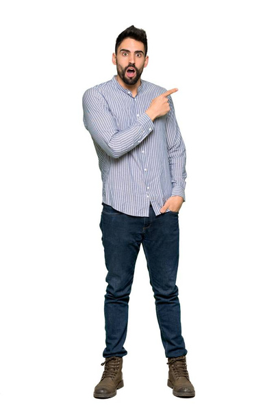 Full-length shot of Elegant man with shirt surprised and pointing side on isolated white background - Foto, afbeelding