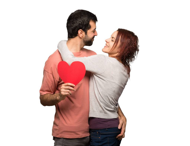 Пара в день Святого Валентина держит символ сердца и целуется на изолированном белом фоне
 - Фото, изображение